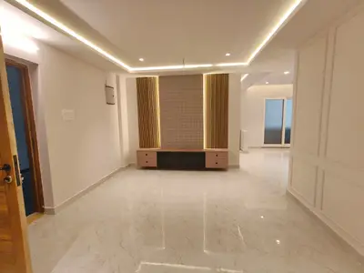 Living room of the Elite Homes 3 BHK sample flat with fluted TV wall and cove ceiling lighting